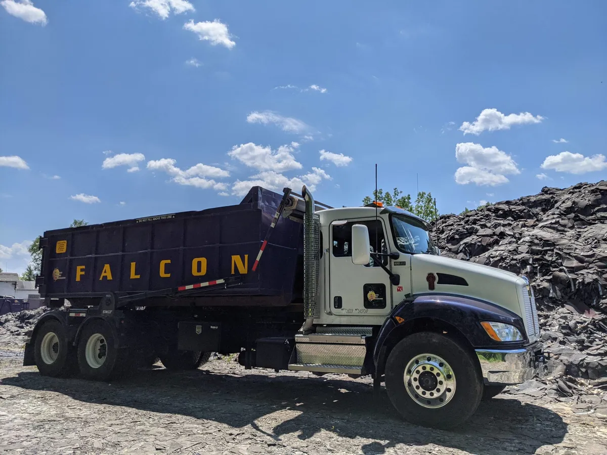 Camión roll-off de Falcon Green Resources transportando un contenedor morado