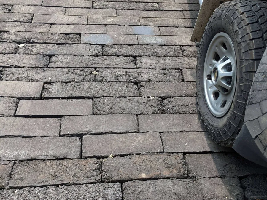 Opona ciężarówki spoczywająca na drodze z cegieł z gontów