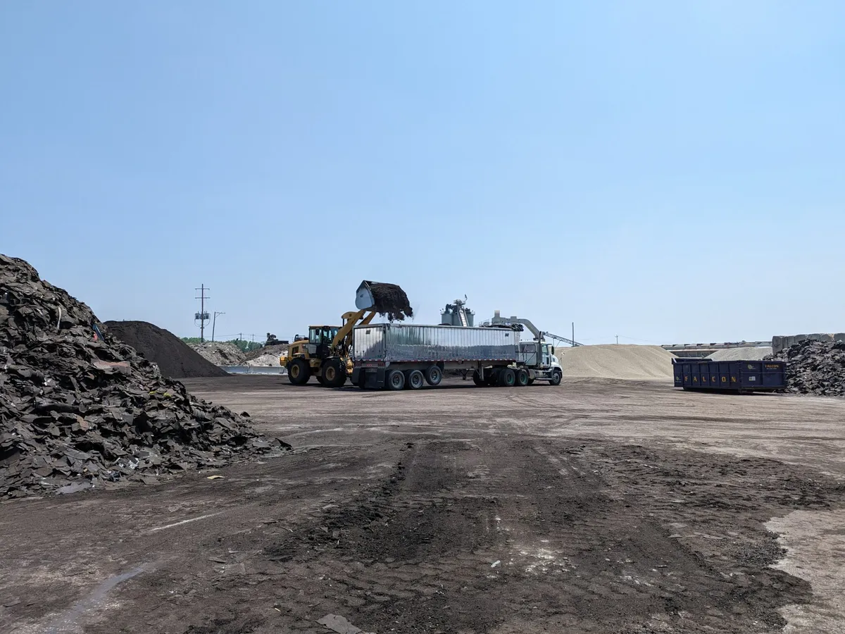 Ładowarka kołowa napełniająca przyczepę na placu recyklingowym Falcon Green Resources